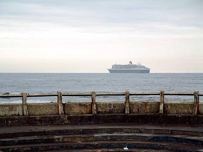 Queen Mary 2 heading north away from Tynemouth. 12 july 2004. In the foreground Tynemouth rockpool